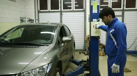 Mechanic lifts the machine holding the button lift Video stock 62480667