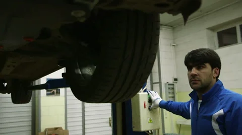 Mechanic lifts the machine holding the button lift Stock Footage 62480681