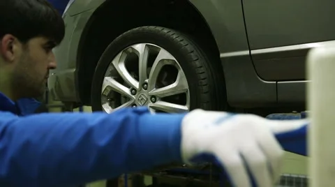 Mechanic lifts the machine holding the button lift Stock Footage 62480685