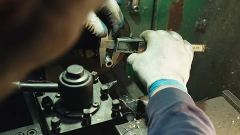 Mechanic in a locksmith workshop uses a professional electronic caliper to Stock Footage 285642173