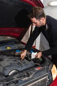 Mechanic looking at oil level in the engine of the car. Concept of automobile Stock Photos