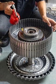 Mechanic lubricating automatic transmission rotating clutch hub with oil ca.. Stock Photos