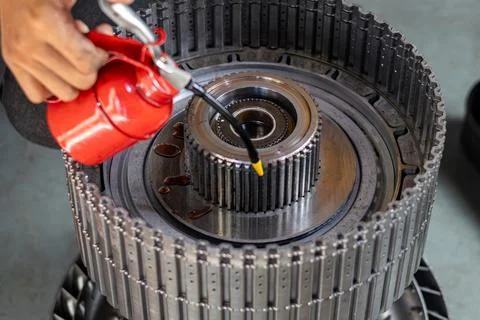 Mechanic lubricating automatic transmission rotating clutch hub with oil ca.. Foto stock