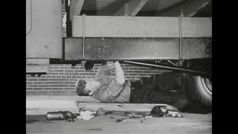Mechanic lying under truck and try to fixes transmission - 1945 Stock Footage 101407567