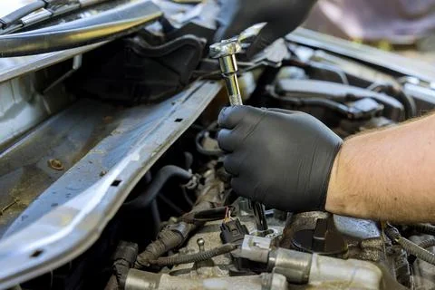 Mechanic makes diagnostics and replacement on a car spark in the engine with car Foto stock