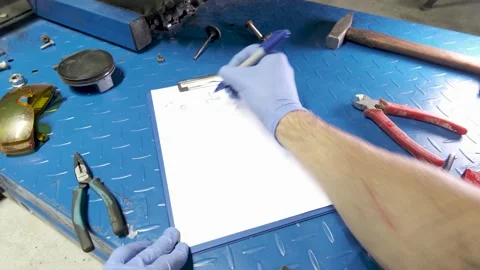 A mechanic makes a to-do list for 2022 Stock Footage 162867116