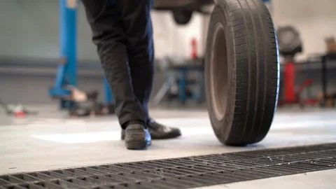 Mechanic man change a wheel tire and service maintenance the suspension Видео 115887553