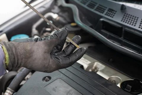 Mechanic man checking engine oil refill car maintenance Stock Photos