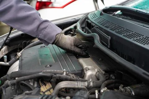Mechanic man checking engine oil refill car maintenance Stock Photos