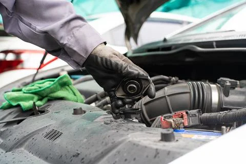 Mechanic man checking engine oil refill car maintenance Stock Photos