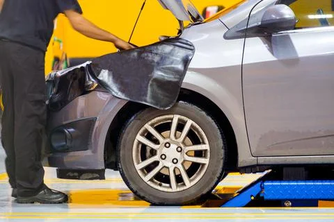 Mechanic man checking problem in front engine car Stock Photos
