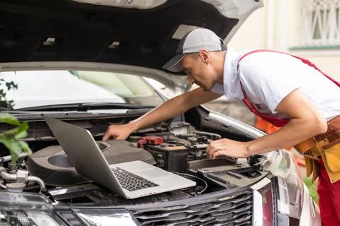 Mechanic man close up using laptop computer examining tuning fixing repairing Stock Photos