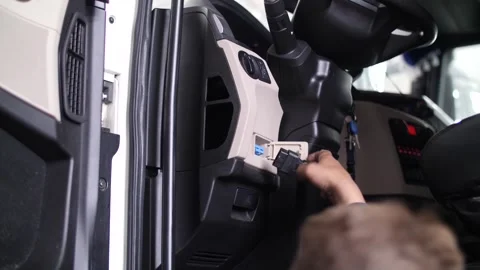 Mechanic man hand installing digital tachograph in truck dashboard. Stock Footage 313815189