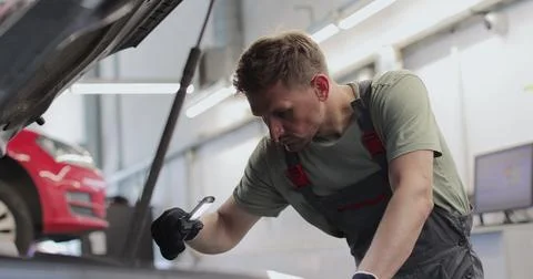 Mechanic man with lamp working at workshop. concept car service, repair, main Stock Photos