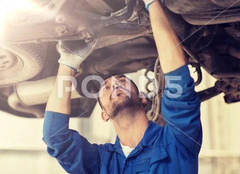 Mechanic man or smith repairing car at workshop Stock Photos