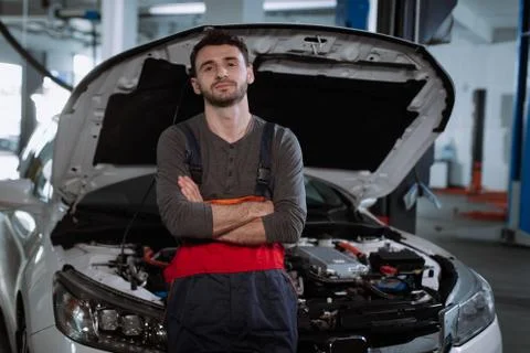 Mechanic man in a uniform write the problem of the car in a map in the modern Stock Photos