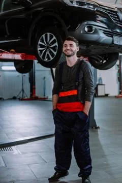 Mechanic man in a uniform write the problem of the car in a map in the modern Stock Photos
