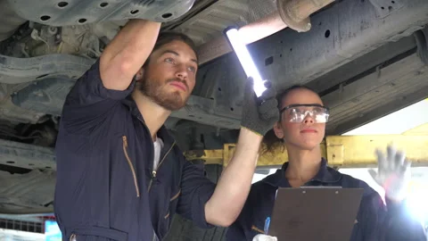 Mechanic man using flashlight  and manager woman holding clipboard checking l Stock Footage 147367506