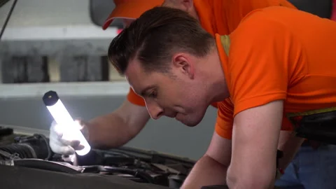 Mechanic manager man checking car with assistant worker using flashlight in w Stock Footage 147367481