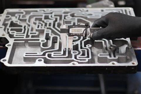 Mechanic measuring a channel width on an automatic transmission valve body .. Stock Photos
