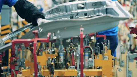 Mechanic moving a ready-made auto part ona car factory facility. Modern Video stock 140979133