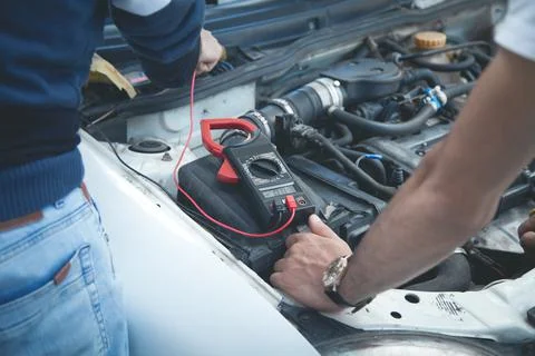 Mechanic with a multimeter testing car engine. Car service Stock Photos