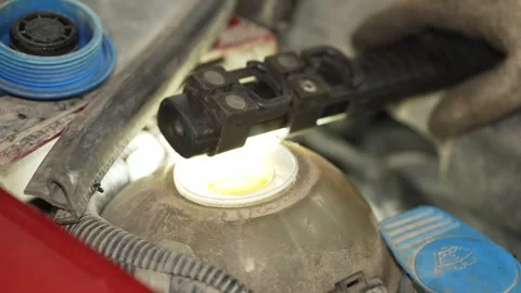 Mechanic opening blue cap of car coolant expansion tank reservoir. Stock Footage 341487566