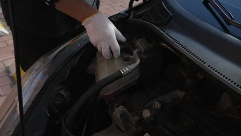 Mechanic opening car engine coolant reservoir cap Видео 345056831