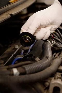 A mechanic opens the engine cap to check the oil level Stock Photos