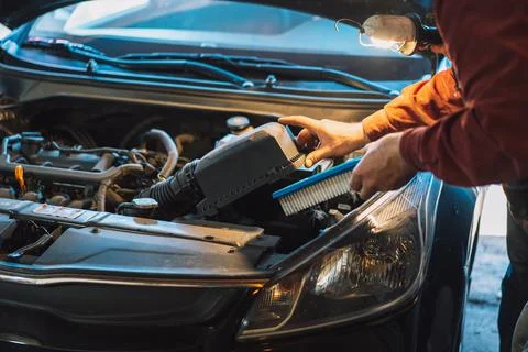 The mechanic opens the tray and pulls out the air filter Stock-Fotos