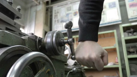 Mechanic operating old lathe machine. Rotation of the metal handle. Stock Footage 87725682
