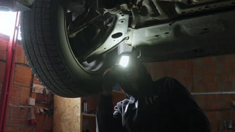 Mechanic performing diagnostics of the car front suspension and control arm Stock Footage 315006809