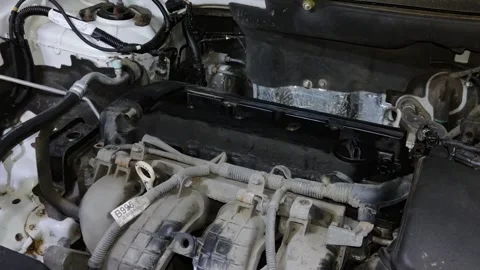 Mechanic performing engine repair with screwdriver tool in natural light Vídeo Stock 347085135