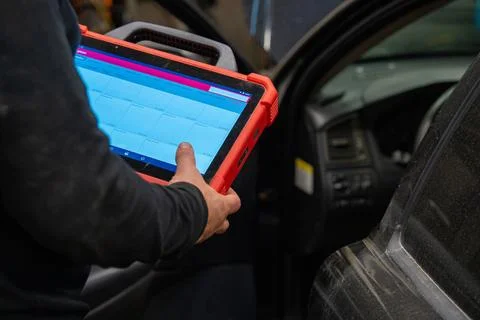 Mechanic performing vehicle computer system analysis Foto stock