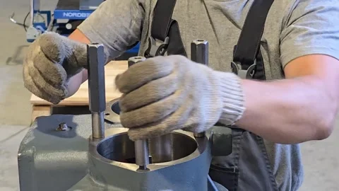 Mechanic placing metal rods into engine block cylinders Video stock 314210096