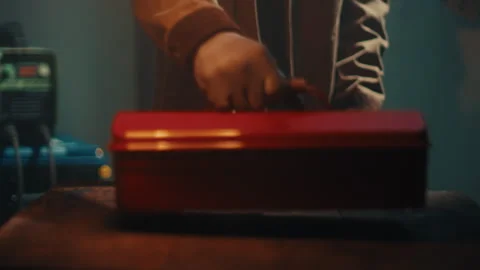 Mechanic Placing Red Metal Toolbox on Work Surface in Dim Workshop Environment Stock Footage 331696751
