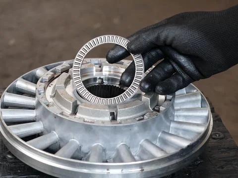 Mechanic placing a thrust needle roller bearing onto a transmission component Stock Photos