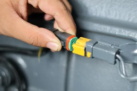 Mechanic plugging electrical connector. Stock Photos