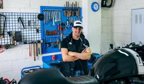 Mechanic posing with a motorcycle Stock Photos