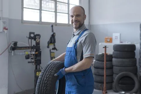 Mechanic posing with a tire Stock Photos