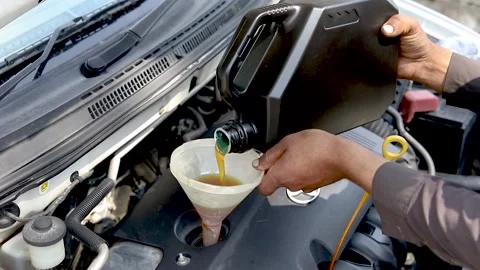 Mechanic pouring new engine oil into the car's engine 库存影片 236889228