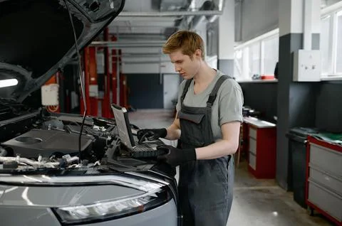 Mechanic providing computer diagnostics to find cause of car failure Stock Photos