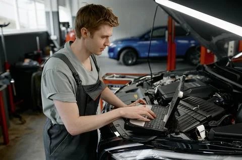 Mechanic providing computer diagnostics to find cause of car failure Stock Photos
