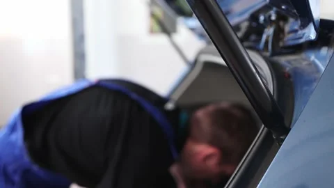 A mechanic pulls out a spare wheel from the trunk of a car. Selective focus Stock Footage 165836582