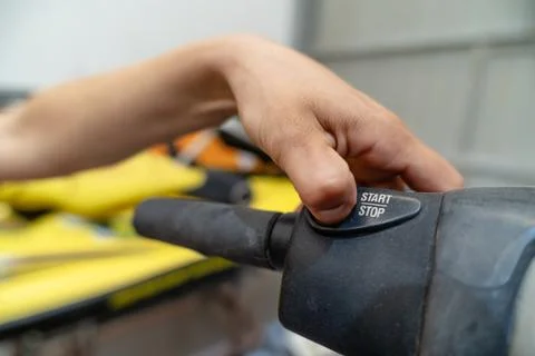 Mechanic pushing start button on machine handlebar Stock Photos