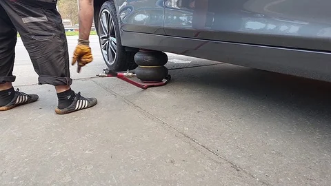 The mechanic puts the Jack under the car, service station 動画素材 120939970
