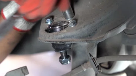 The mechanic is putting the upper control ball joint nut. Video stock 244997410