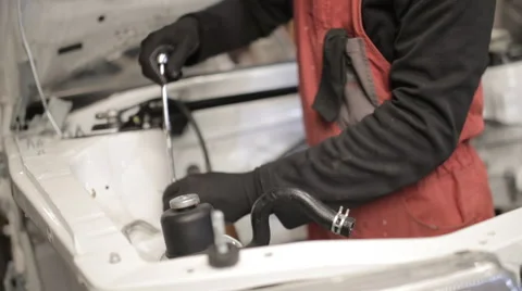 Mechanic in red overalls assembles the car, hands close-up Stock Footage 58135008
