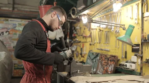 Mechanic in red overalls working grinder and sparks fly Stock Footage 58135045