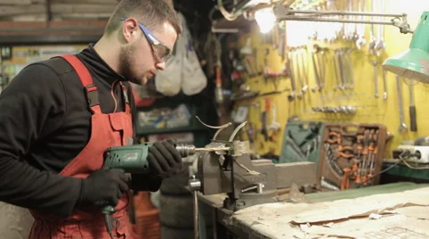 Mechanic in red overalls working hand drill Video stock 58135087
